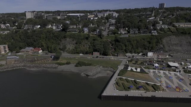 Drone flies backwards along northern edge of Quai Paquet on sunny summer day in Levis, Quebec, Canada