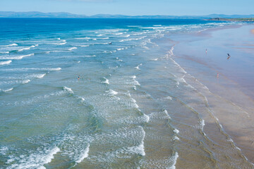 Enjoying serene beach day at Finner Strand, Donegal, Ireland with gentle waves and sunlit shores