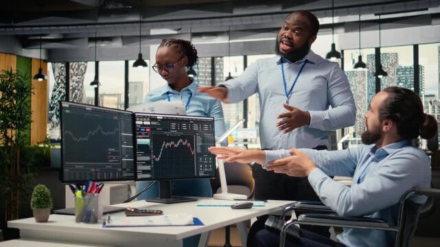 Happy worker with paraplegia and prop firm colleague doing high five after successful trading operations. Cheerful trader in wheelchair and coworker celebrate portfolio profits, camera A