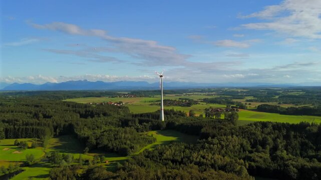 Aerial view of wind turbine in Bavaria, Ebersberg region, Germany. Luftaufnahme einer Windturbine vor dem Hintergrund der Alpen in Bayern, Deutschland. Wind turbine on golf course overlooking alps. 