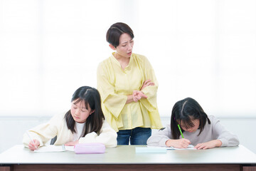 勉強をする女の子　先生　家庭教師　教育ママ