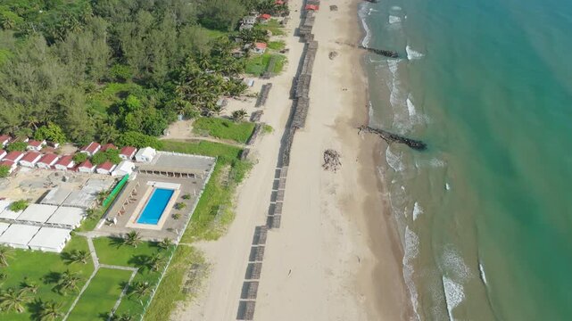 Top-down aerial over beachfront pool complex, sandy shoreline and turquoise sea in Tuxpan, Veracruz, Mexico, 4K