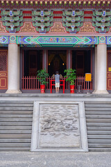 Boy praying in front of a decorated temple altar in Taichung, Taiwan