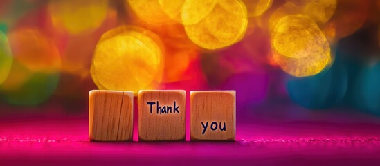 Thank you message on wooden blocks, colorful bokeh background