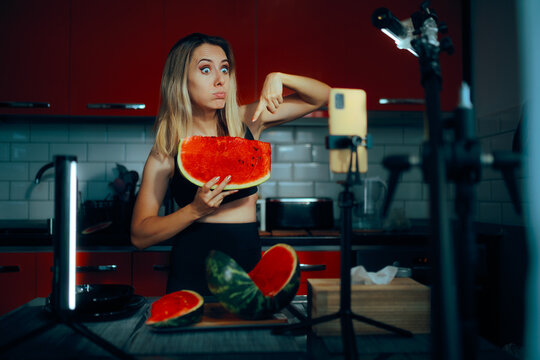 Funny Fitness Influencer Pointing to her Watermelon Slice on Camera. Carefree wellness content creator recommend her fruit diet