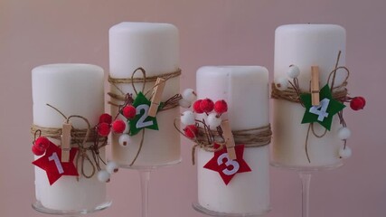 Traditional Burning Christmas Wax Candles with numbers counting down for Christmas New year and Christmas preparation. Four-week advent candles on table. Handmade eco-friendly decor. Sustainable