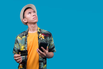Thoughtful Asian Voyager Man Holding Phone And Credit Card While Looking away