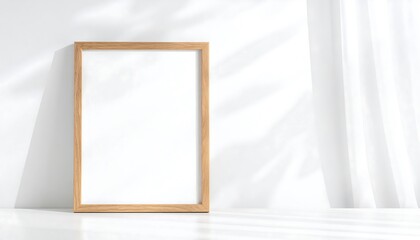 A light-filled, minimalist interior scene showcases a light wooden picture frame against a bright white wall and sheer curtains, creating a tranquil and elegant aesthetic.