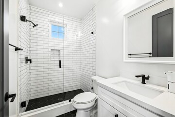 Modern white bathroom with subway tiles and black fixtures.