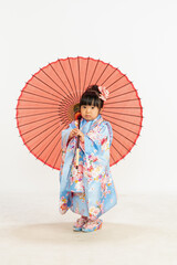 Japanese Girl in Blue Kimono Holding Traditional...