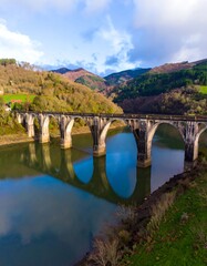 Fototapeta premium Stone arch bridge over calm water