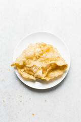 Overhead view of dublan northern nigerian snack, top view of dublan on a plate, flaky fried dough coated in syrup and sesame