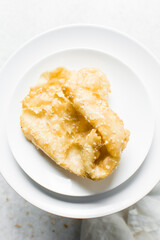 Overhead view of dublan northern nigerian snack, top view of dublan on a plate, flaky fried dough coated in syrup and sesame