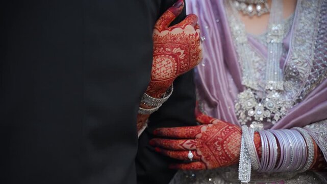 Bridal Mehndi Hands holds groom hand. closeup during Outdoor Wedding Photoshoot 