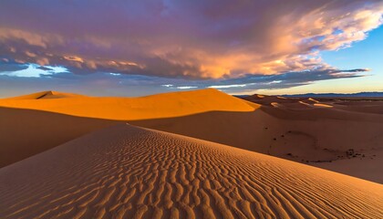 Dramatic sand dunes bathed in warm sunset light, showcasing intricate patterns and a dramatic sky.