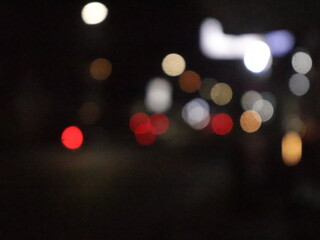 A stunning bokeh effect at night, showcasing blurred city lights in vibrant tones of red, orange,...