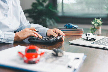 Dealership service desk, professional car salesman assists client with sale, finance documents for...