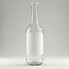 An empty clear glass bottle with a white label and silver cap against a plain light gray background