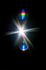 Abstract light burst, colorful lens flare on black background