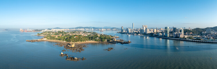 Xiamen, China, presents a wide panoramic view of its beautiful coastal city skyline and a green...