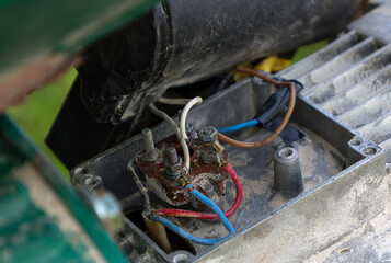 ​A close-up of electrical connections and wires in an old mechanism. Various colored wires,...