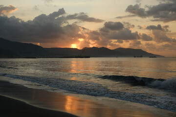 Sunrise or Sunset over Ocean Coast with Mountains