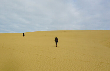 A woman walking on the Giant Sand Dunes, Cape Reinga, New Zealand.