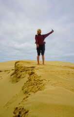 A woman walking on the Giant Sand Dunes, Cape Reinga, New Zealand.
