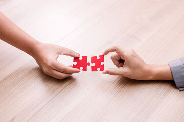 woman hand holding jigsaw puzzle pieces in office