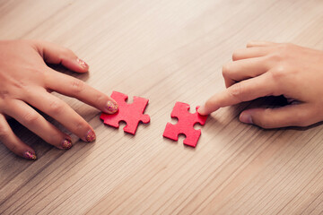 woman hand holding jigsaw puzzle pieces in office