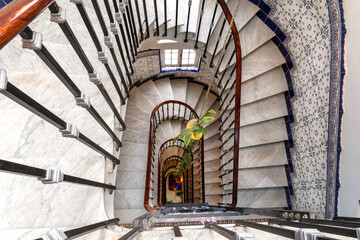Spiral staircase. Top view. Chandelier and ceramic tiles on the wall