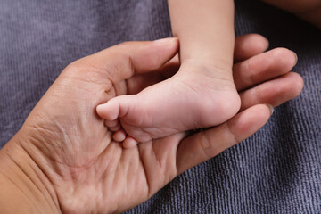 Parent holding feet of newborn baby in the hands