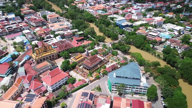 Aerial establishing of Siem Reap cityscape with traditional rooftops and colorful streets, orbit