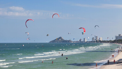 Coastal view of many professional and beginner Kite Surfers on the city beach
