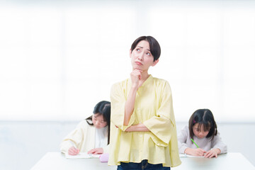 勉強をする女の子　考え事をするお母さん