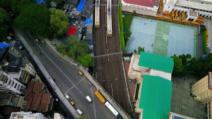 Aerial top down view of Mumbai rail road with moving vehicles and trains, Local trains are major mode of commute in Mumbai, India.