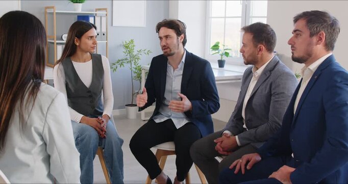 Group of business professionals conducts a team meeting in a circle within the office. Teamwork, collaboration, and open communication foster a productive discussion and effective business outcomes.