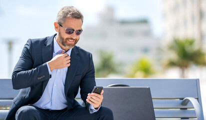 Business communication. Casual business man chatting on phone outdoor. Businessman using phone. Man...