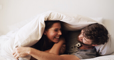 Couple, laughing and cuddle in bed with happiness, moment and connection for bonding in home....
