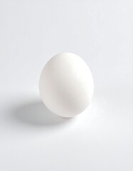 Single white egg against white background