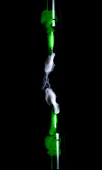 Green glass bottle with strange swirling smoke inside and out creating unique shapes and patterns