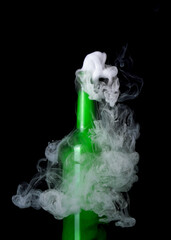 Green glass bottle with strange swirling smoke inside and out creating unique shapes and patterns