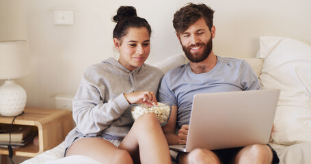 Couple, laptop and movie with popcorn on bed for weekend break, series subscription and bonding. Home, happy people and tech with snacks in bedroom for watching film, relationship and streaming show