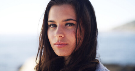 Portrait, travel and woman at sea for holiday, summer trip and adventure in nature. Beach, tourist and serious person outdoor with confidence on vacation break at ocean on island in Australia