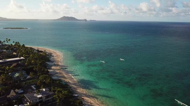 Drone shot of Lanikai Beach with crystal clear water at sunset. Kailua, Oahu, Hawaii during summer with row boats in the background. Oceanfront villas
