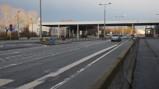 Car driving through an empty border crossing checkpoint