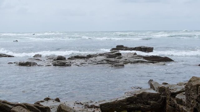 Beautiful coastal landscape showcasing rocky shorelines and gentle waves on a cloudy day