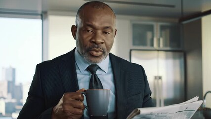 Man reading newspaper and enjoying coffee in the morning - Powered by Adobe