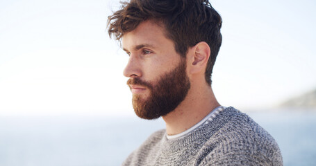 Serious, man and thinking for travel at ocean for fresh air, sightseeing and vacation reflection. Male person, rest and thoughts for tourist planning, holiday memory and morning peace of getaway trip