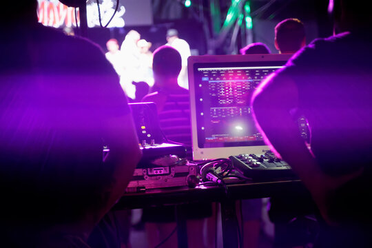 Sound engineers working during live concert, mixing music on audio console